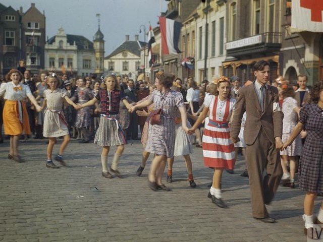 Foto van mensen die hand in hand door de straat gaan ten tijden van de bevrijding in 1945